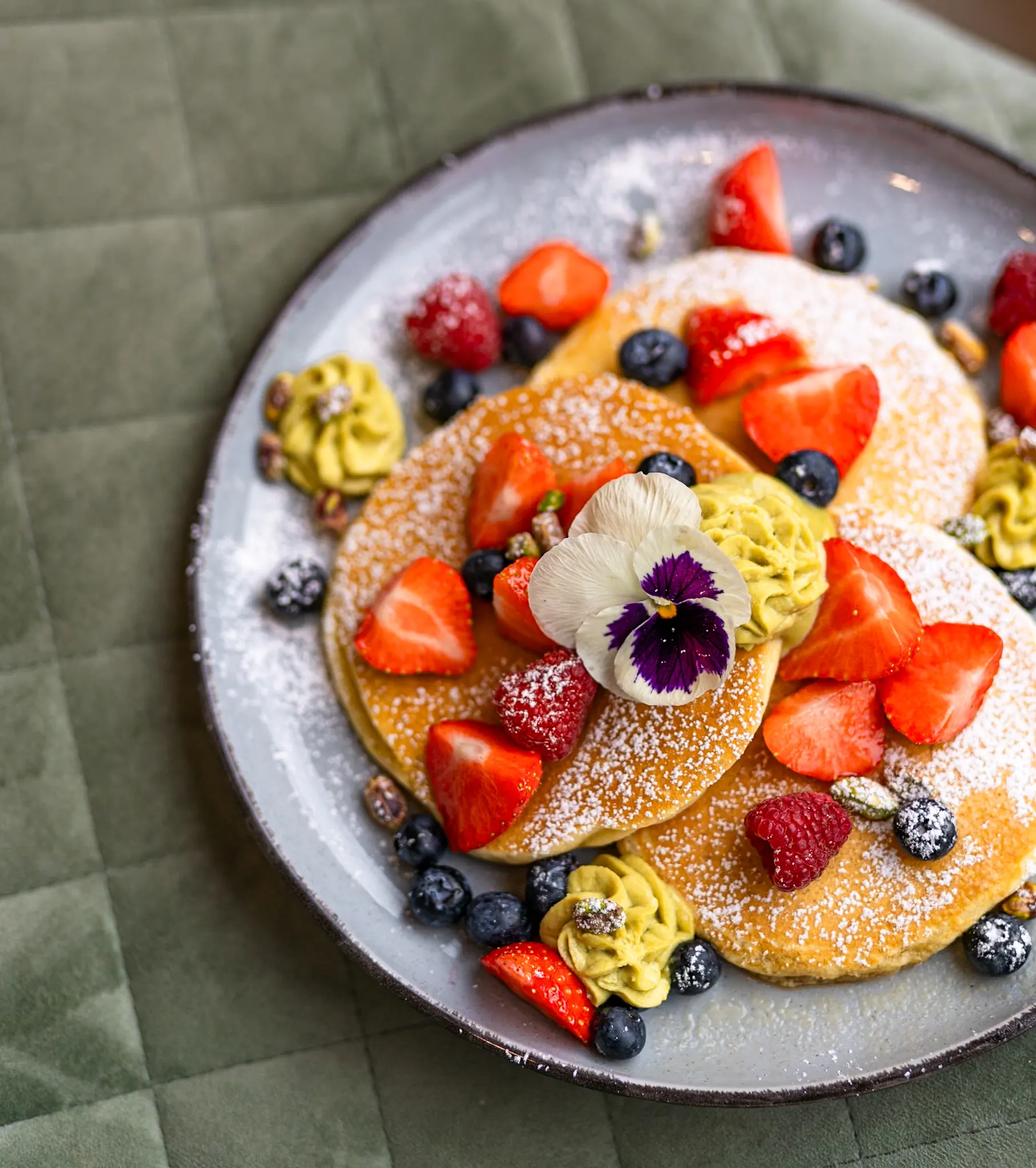 A sweet brunch plate with fruit and edible flowers.