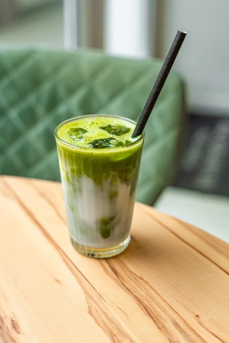 Boisson glacée verte et lactée servie dans un verre.